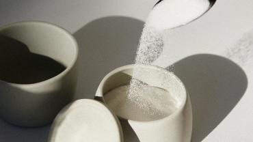 Spoon pouring sugar into a sugarbowl