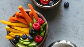 stainless steel lunch containers holding mixed berries and veggie sticks