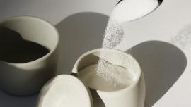 Spoon pouring sugar into a sugarbowl
