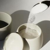 Spoon pouring sugar into a sugarbowl