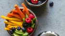 stainless steel lunch containers holding mixed berries and veggie sticks